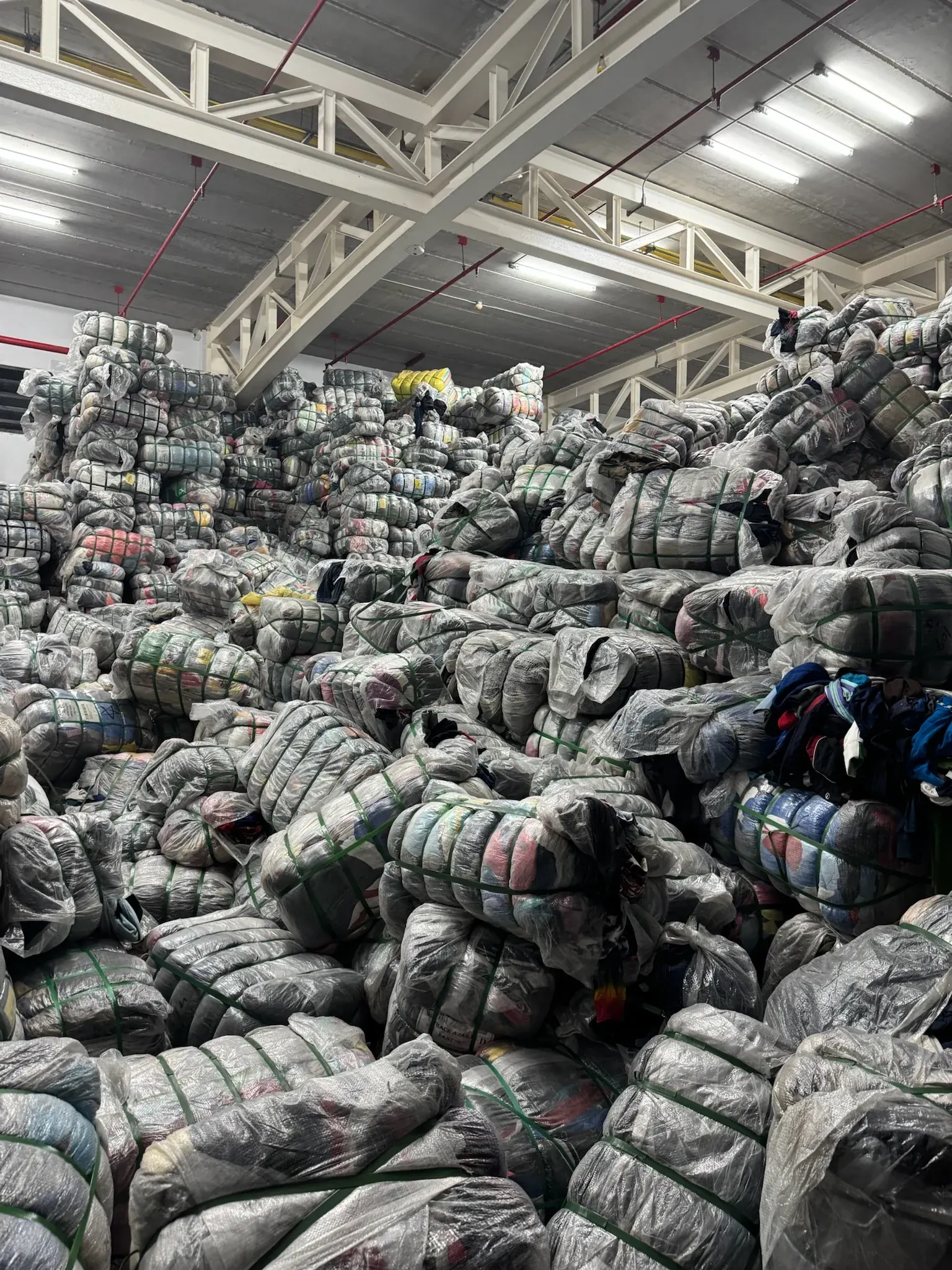 Montagne de balles de vêtements de seconde main chez un fournisseur à l'étranger, avant la sélection des lots
